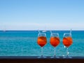 Refreshing aperitif Aperol spritz on a background of blue sea an