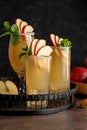 Refreshing apple cocktail drinks with fresh red apples, dark background