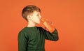 Refreshing beverage concept. Water balance. Small child drink juice orange background. Little boy enjoy drinking fruit