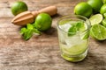 Refreshing beverage with mint and lime in glass on wooden table Royalty Free Stock Photo