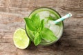 Refreshing beverage with mint and lime in glass on wooden background Royalty Free Stock Photo