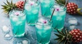 Refreshing blue cocktails with ice cubes and pineapple garnish on a light blue surface setting scene Royalty Free Stock Photo