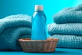 Refreshing blue laundry detergent bottle surrounded by folded towels in a fabric storage setting Royalty Free Stock Photo