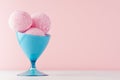 Refreshing classic pink creamy ice cream balls in elegant blue bowl on white wooden table and soft light pastel pink background