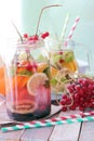 Refreshing cocktail, detox water from organic fruits and berries, mint leaves in glass jugs on a wooden table