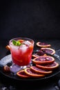 Refreshing cocktail with red blood orange, ice and mint