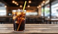 Refreshing cola drink with ice and straw on a wooden table