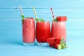 Refreshing colorful watermelon juice with mint and watermelon slice on blue old wooden the table background with copy space