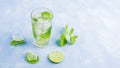 Refreshing cool detox drink with lime and mint on blue background. Summer lemonade or ice tea in a glass. Mojito cocktail with ice Royalty Free Stock Photo