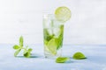 Refreshing cool detox drink with lime and mint on blue background. Summer lemonade or ice tea in a glass. Mojito cocktail with ice Royalty Free Stock Photo