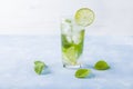 Refreshing cool detox drink with lime and mint on blue background. Summer lemonade or ice tea in a glass. Mojito cocktail with ice Royalty Free Stock Photo