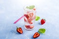 Refreshing cool detox drink with strawberry and mint on blue background. Summer lemonade or ice tea in a glass. Mojito cocktail Royalty Free Stock Photo