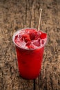 Refreshing cool lemonade with strawberries and ice in plastic glass