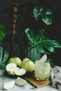 Refreshing delicious of iced guava juice in a glass and sliced guava placed on white marble, houseplant green plant background. Royalty Free Stock Photo