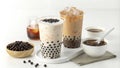 Refreshing display of two plastic cups of iced milk tea with boba tapioca pearls, served with additional tapioca pearls and tea Royalty Free Stock Photo