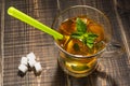 Refreshing drink with lemon, cold tea with ice and mint in a glass cup, near sugar cubes