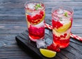 Refreshing drink, lemonade with red currant, lime and ice cubes in glasses on a dark wooden background Royalty Free Stock Photo
