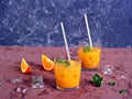 Refreshing drink, orange cocktail with basil in glasses Royalty Free Stock Photo