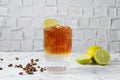 Refreshing espresso tonic drink with lime and coffee beans on white marble table Royalty Free Stock Photo