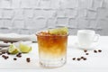 Refreshing espresso tonic drink with slice of lime and coffee beans on white wooden table Royalty Free Stock Photo