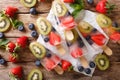 refreshing fruit popsicle lollies with berries, fruits peppermint on wooden background. horizontal top view