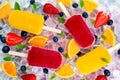 Refreshing fruit popsicle lollies on ice background with berries, peppermint