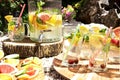 A refreshing fruit punch with lemon, lime, orange, grapefruit and mint in glass glasses stands on a round tray of mango tree Royalty Free Stock Photo