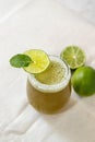 Refreshing glass of beverage with green lime on the table for garnish Royalty Free Stock Photo