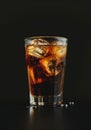 Refreshing glass of cola with ice on a dark background