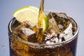 Refreshing glass of cola with lemon and ice