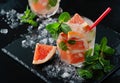 Refreshing grapefruit cocktail with ice and mint on a black background Royalty Free Stock Photo