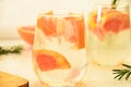 Refreshing grapefruit cocktail with ice and rosemary on a white background. rosemary on the table. or detox water or Royalty Free Stock Photo