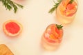 Refreshing grapefruit cocktail with ice and rosemary on a white background. rosemary on the table. or detox water or Royalty Free Stock Photo