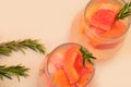 Refreshing grapefruit cocktail with ice and rosemary on a white background. rosemary on the table. or detox water or Royalty Free Stock Photo