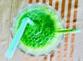 Refreshing Green Juice on Table with Glass and Straw