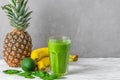 Refreshing green smoothie made of spinach, pineapple, banana and avocado in a glass with fresh fruits and chia seeds on Royalty Free Stock Photo