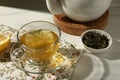 Refreshing green tea in cup and dry leaves on white table, closeup Royalty Free Stock Photo