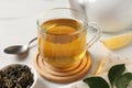 Refreshing green tea in cup and leaves on white table, closeup Royalty Free Stock Photo