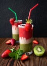 Refreshing, healthy three-layer cocktail of strawberries, banana, kiwi, mint. Healthy food, vitamins. Wooden background