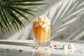 Refreshing iced coffee with marshmallows and palm leaf shadow on marble surface Royalty Free Stock Photo