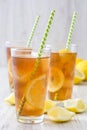 Refreshing iced tea with lemon on white wood