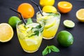 Refreshing lemonade in glass with limes, lemons and orange Royalty Free Stock Photo