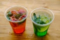 Refreshing lemonades with ice in plastic glasses