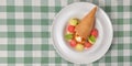 Refreshing melon ice cream with a cone in a white plate. Delicious summer dessert. Cold ice cream fruit sorbet