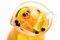 Refreshing non-alcoholic summer drink with orange in a glass pitcher close up, soft focus