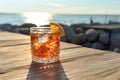 Refreshing Old fashioned cocktail bourbon whiskey and bitters on wood table in front of blue sky on summer sea. generative ai