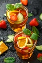 Refreshing Pimms Cocktail with Fruit and vegetables on rustic black table Royalty Free Stock Photo