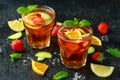 Refreshing Pimms Cocktail with Fruit and vegetables on rustic black table Royalty Free Stock Photo