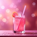 Refreshing pink drink or cocktail with ice and straw on pink background