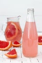 Refreshing pink grapefruit cocktail on old vintage wooden table